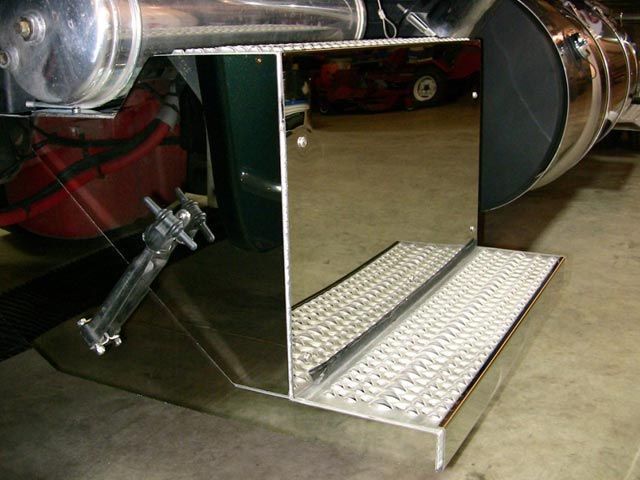Polished metal step on a semi-truck; diamond plate surface, reflective side.