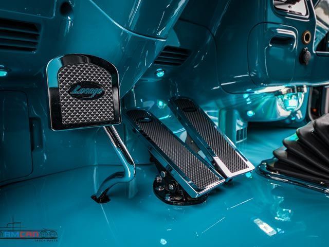 Interior of a teal car with chrome pedals and 