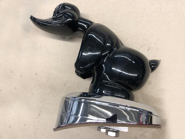 Black Daffy Duck car hood ornament with chrome base.
