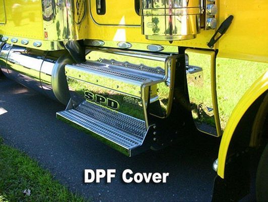 Chrome step and DPF cover on a yellow semi-truck, parked on a paved road.