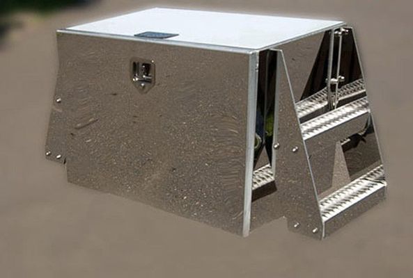 Silver metal truck tool box with treaded side steps and a top-opening lid.
