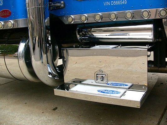 Polished stainless steel step with two blue oval foot pads on a blue semi-truck.