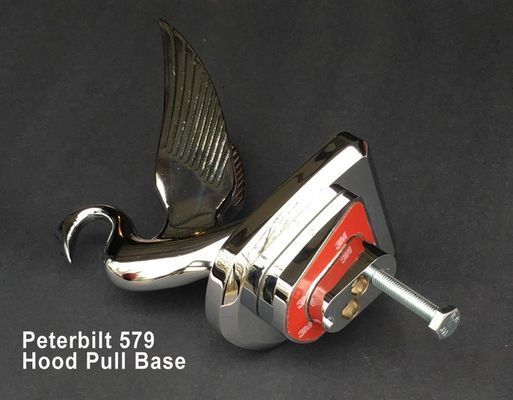 Chrome Peterbilt 579 hood pull base with a bird emblem. Red accent on metal base, silver bolt.