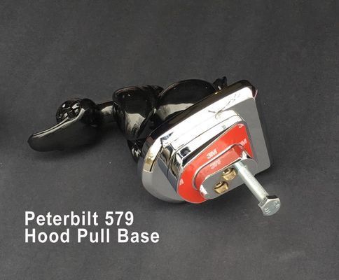 Peterbilt 579 hood pull base, black and chrome, on a dark surface.