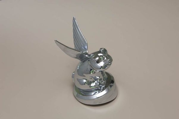 Silver-colored hood ornament shaped like a winged rabbit, possibly a car accessory.