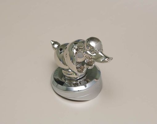 Shiny chrome duck ornament on a circular base.