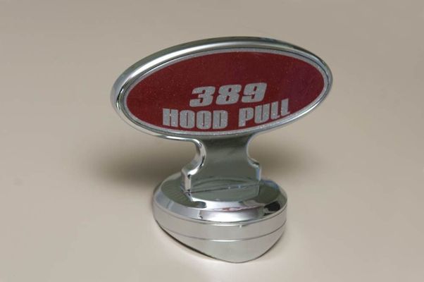 Chrome hood pull with a red oval reading 