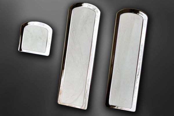 Three rectangular, silver serving trays on a dark gray surface.