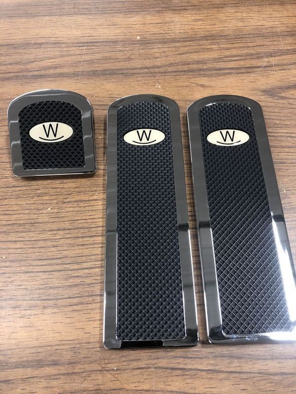 Three black car pedal covers with a 