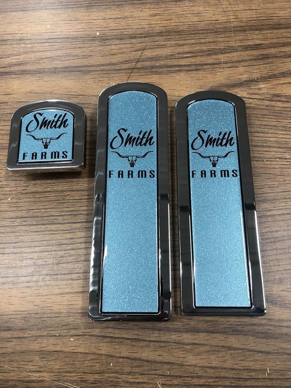 Three Smith Farms emblems: one small, two long. Blue textured background, black border, white text.