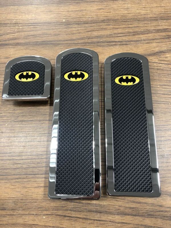 Set of Batman-themed car pedal covers with yellow bat symbol on a black and chrome design.