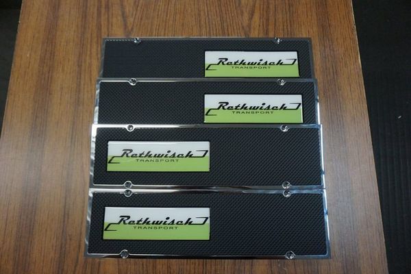 Four license plates with black carbon fiber pattern and