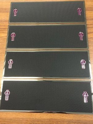 Four black rectangular Kenworth truck logo kick plates with metallic trim.