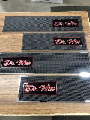 Four black and silver car door sill plates with