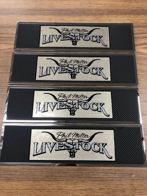 Four black rectangular mats with silver