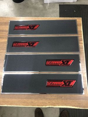 Four black rectangular car door sill plates with