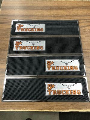 Four rectangular logo stickers for 5-Star Trucking, black textured background, silver and orange logo.