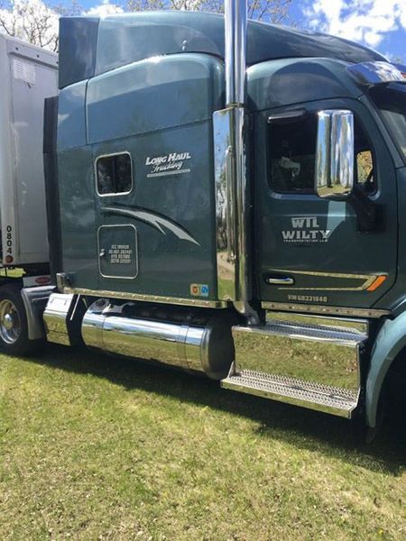 Green semi-truck on grass, chrome accents, 