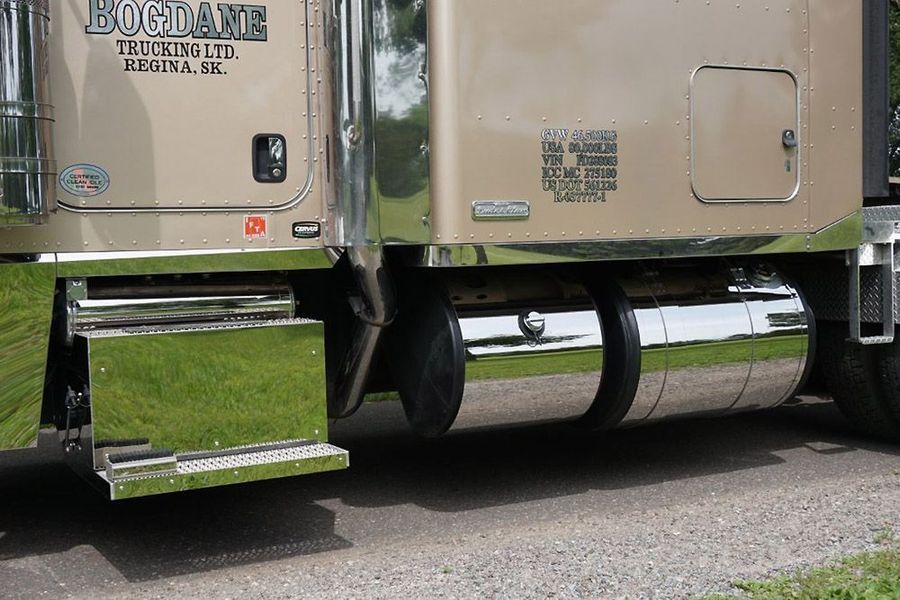 Tan semi-truck with chrome details, including fuel tanks and a step.  