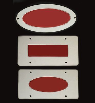 Three metal plates with red inserts: oval, rectangle, and oval.