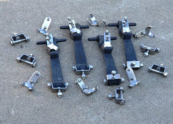 Collection of various metal latches and brackets, scattered on a textured gray surface.