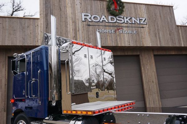 Blue semi-truck with chrome features in front of the 