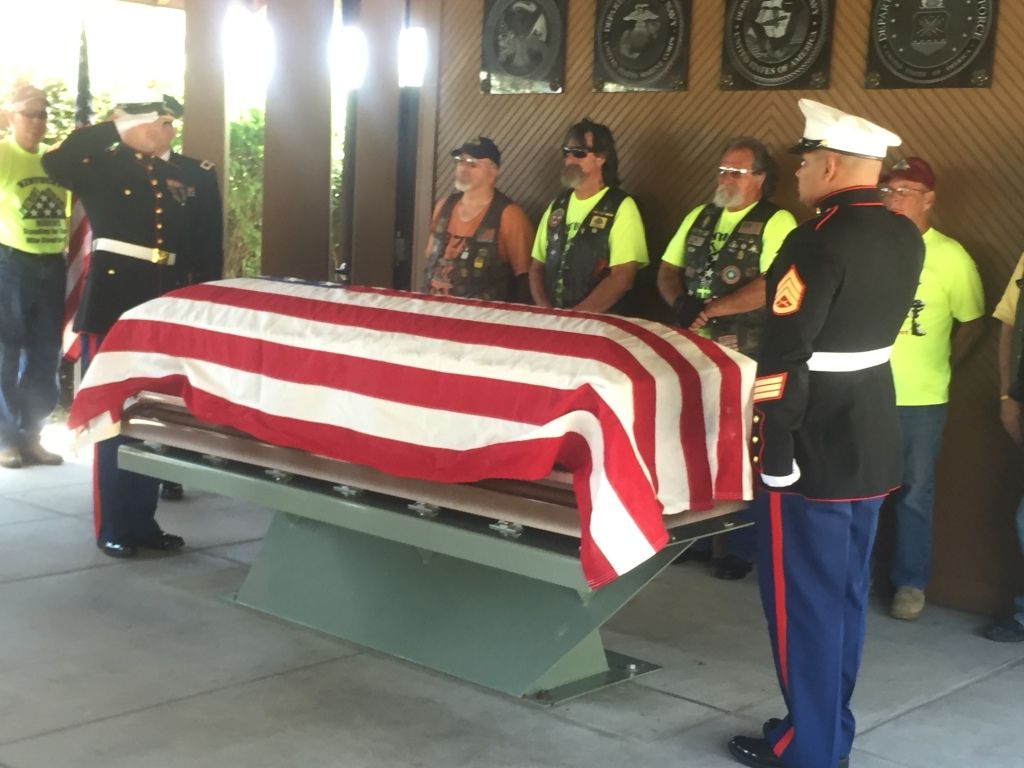 a woman is putting her hand on an american flag at a funeral .