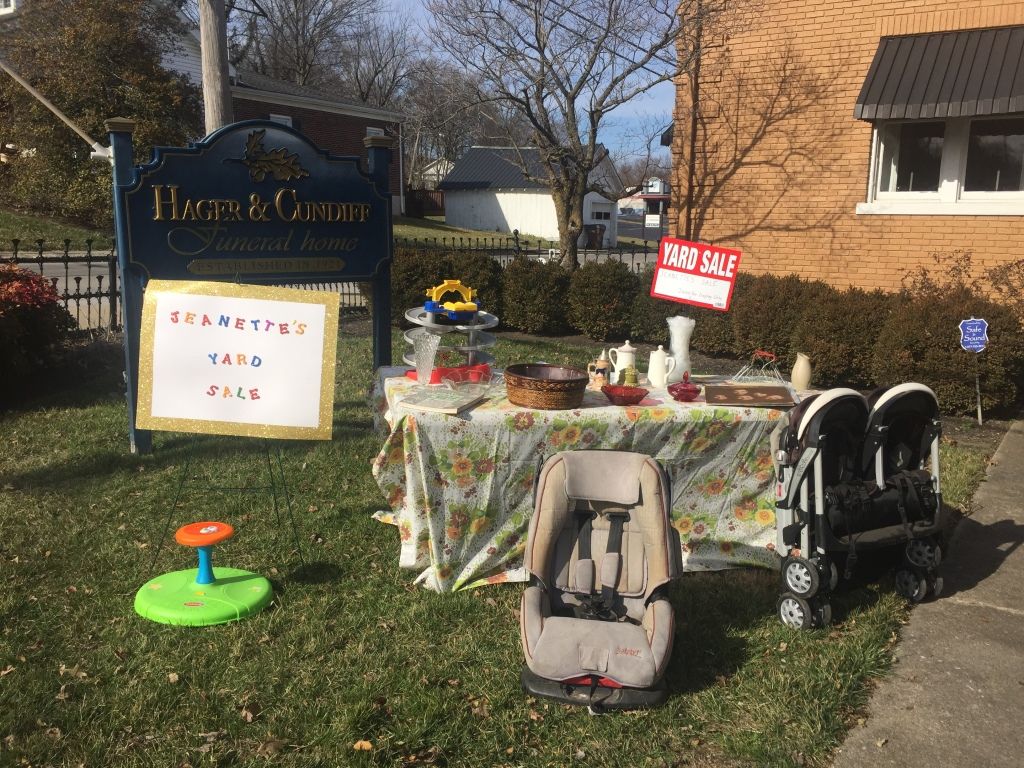 A table with a stroller and a car seat on it in front of a house.