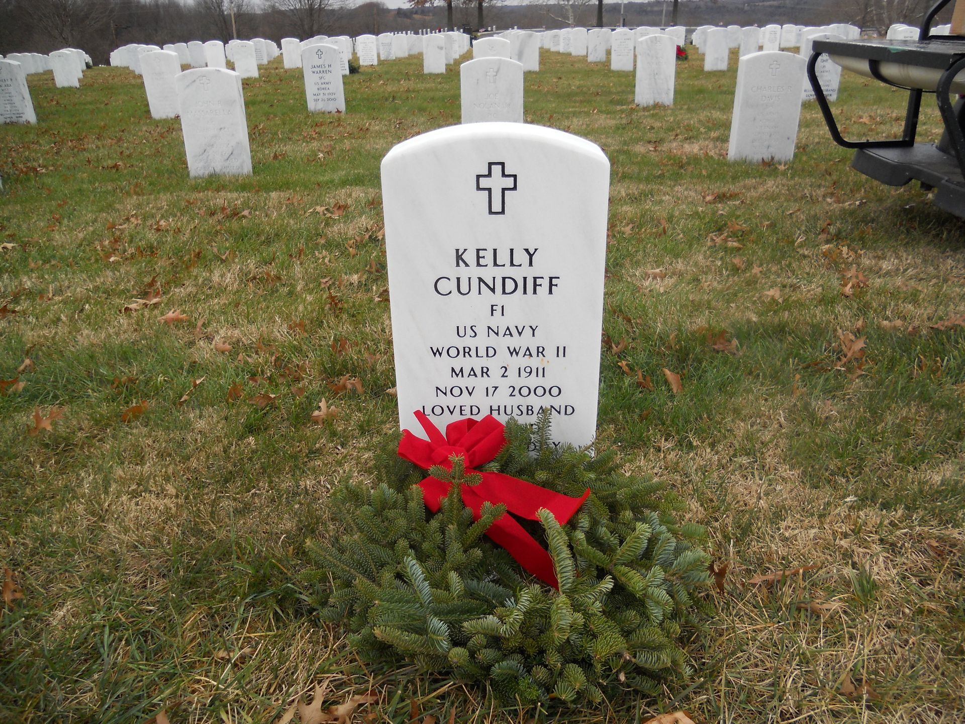 a woman is putting her hand on an american flag at a funeral .