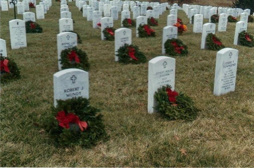 A cemetery with lots of graves and wreaths