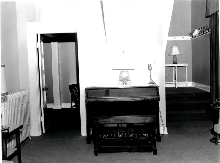 A black and white photo of a piano in a room