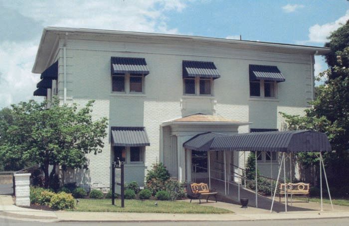 A white building with black awnings on the windows