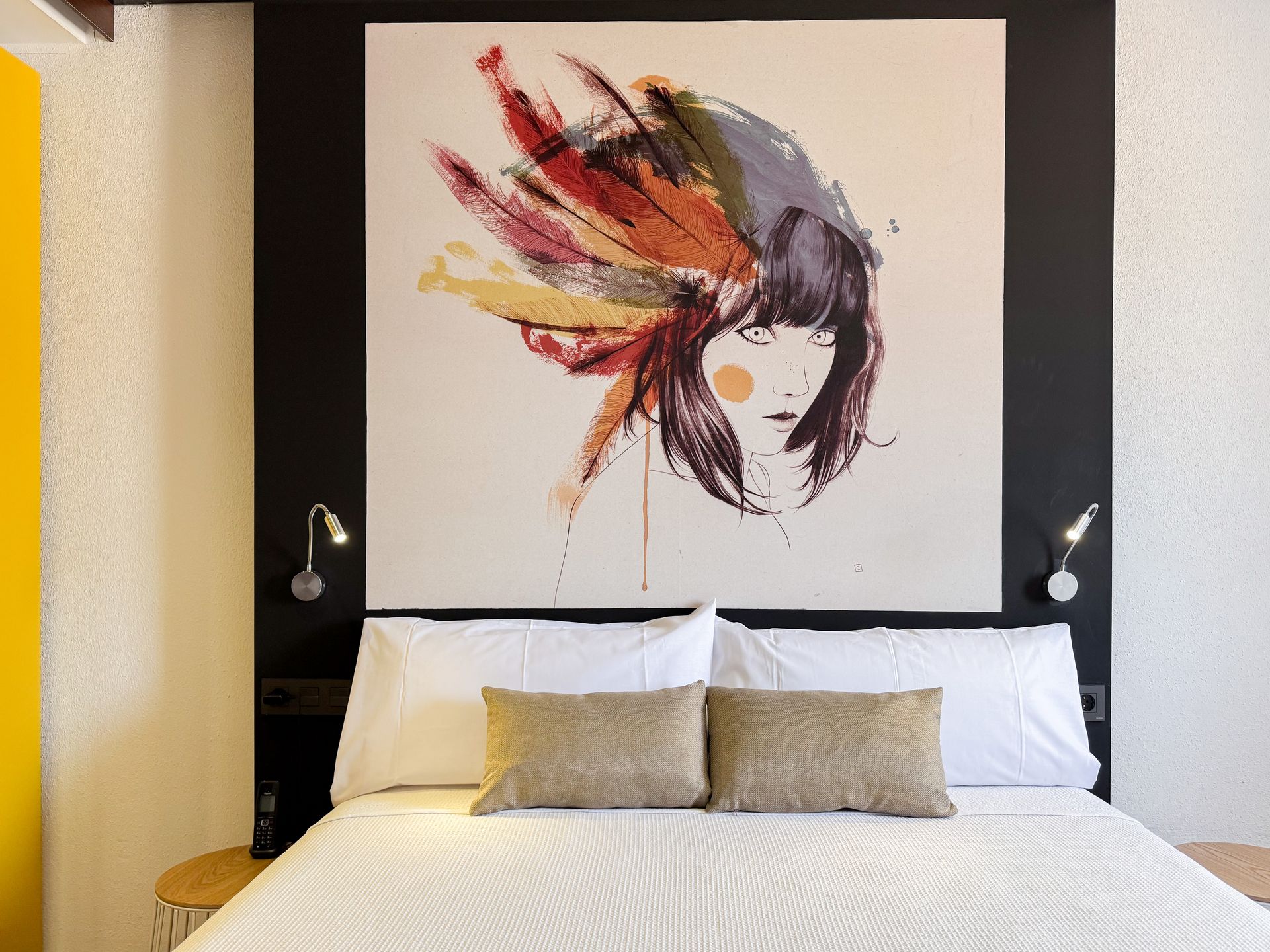 Una cama con un cuadro en la pared encima.