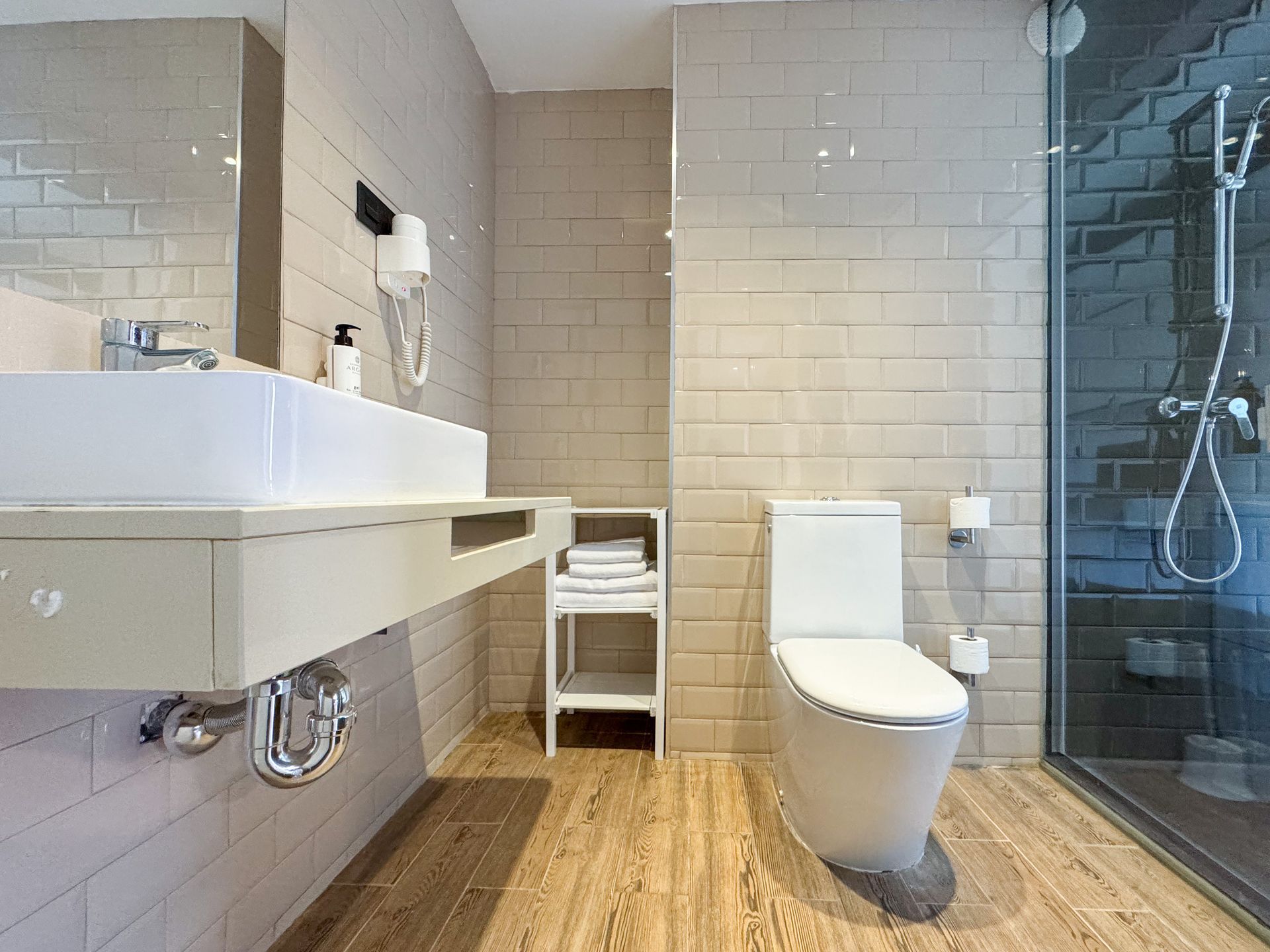 Un baño con inodoro, lavabo y ducha.