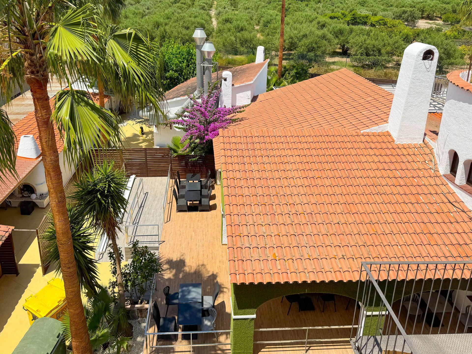 A wooden deck with tables and chairs under umbrellas