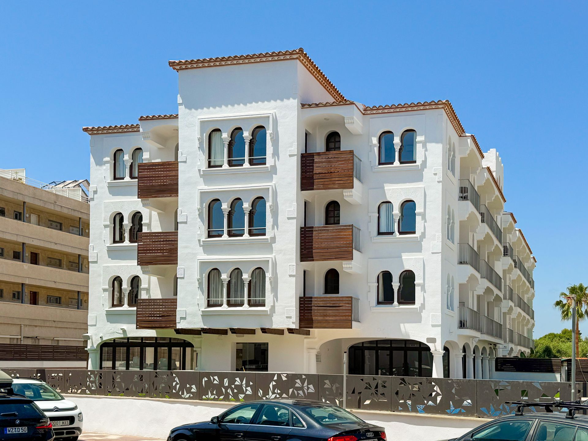 A large white building with a large swimming pool in front of it.