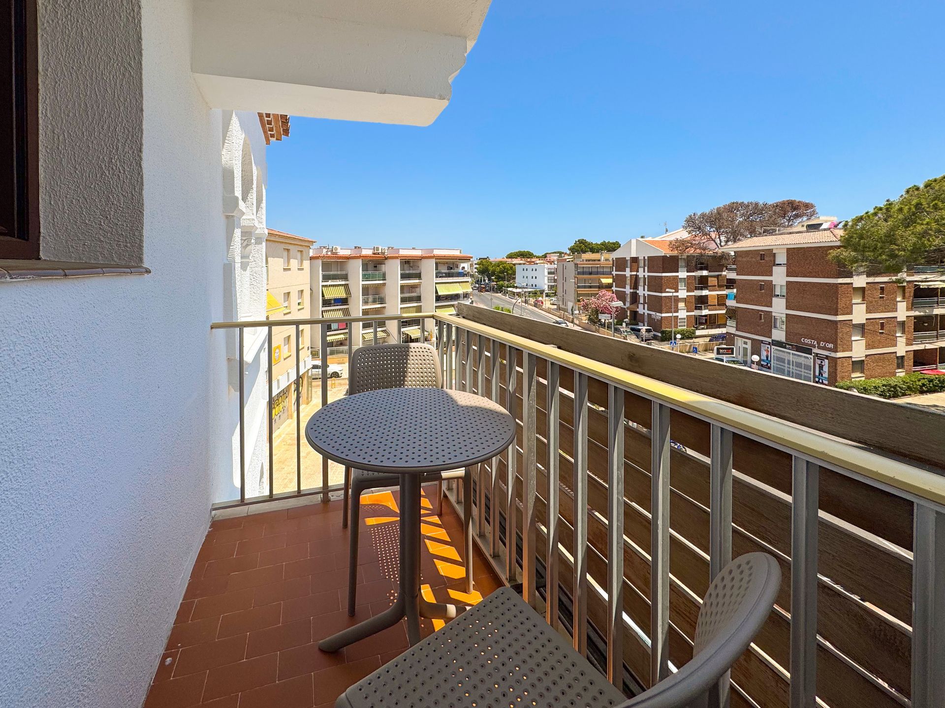 Un balcón con mesa y sillas y vista a una ciudad.