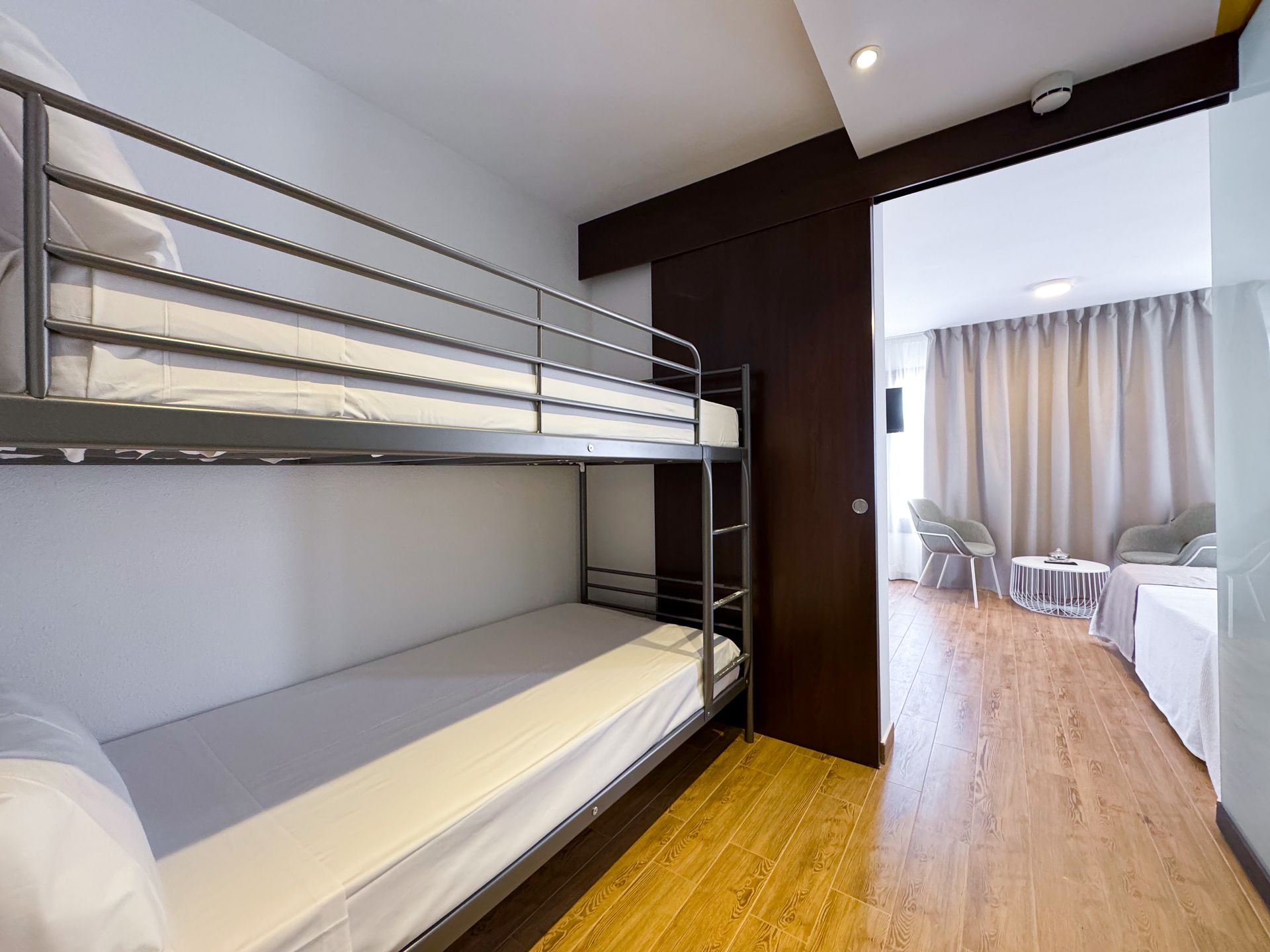 Una habitación de hotel con literas y una sala de estar.