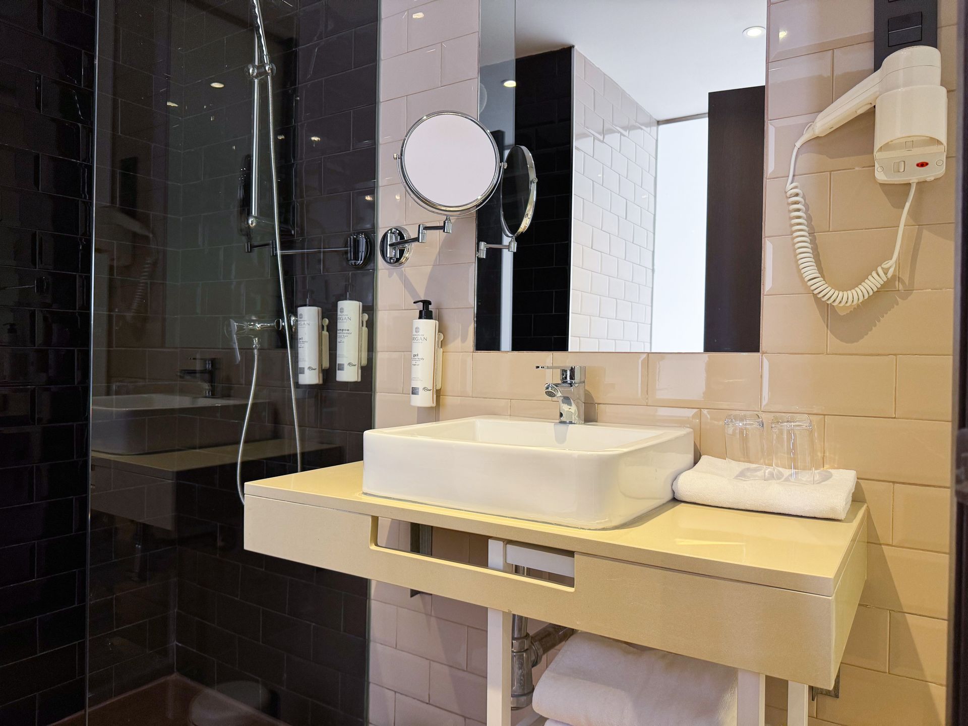 Un baño con lavabo, espejo y secador de pelo.