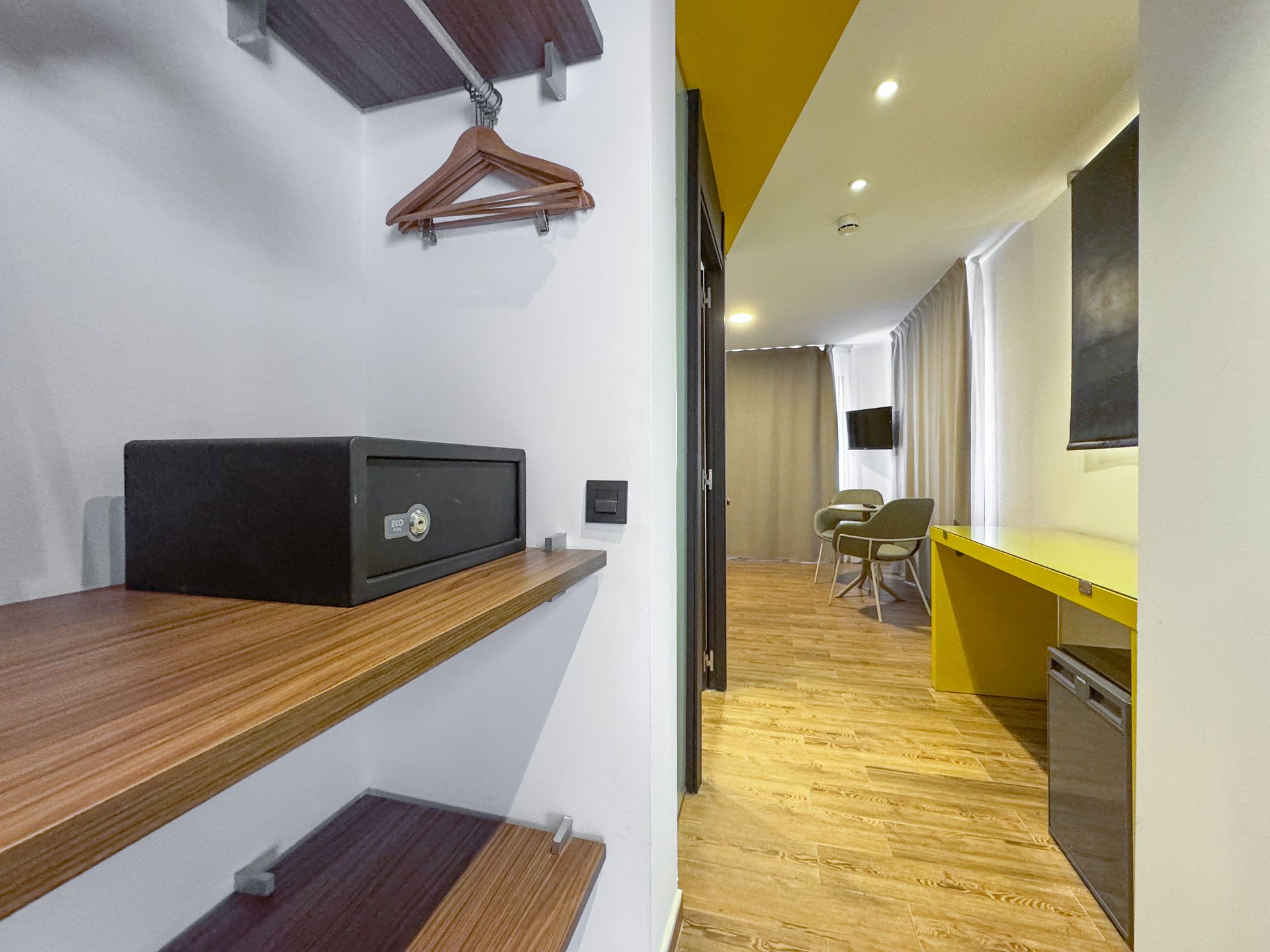 Hay una caja fuerte en el estante del pasillo de una habitación de hotel.