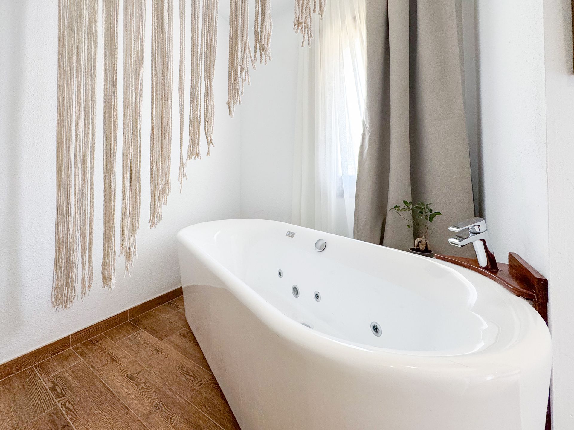 Un baño con bañera de hidromasaje y ventana.