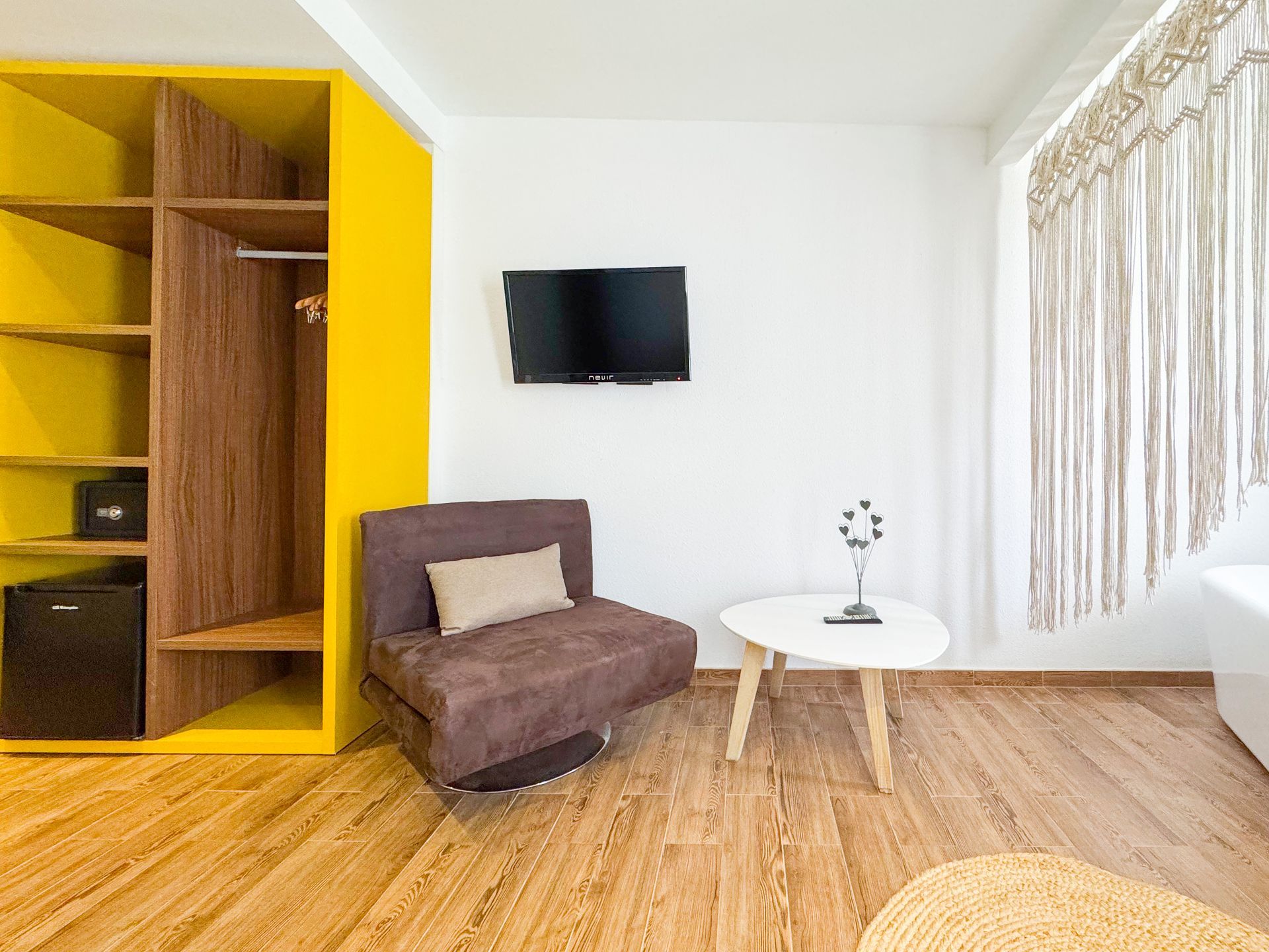 Una sala de estar con una silla, una mesa y una televisión.