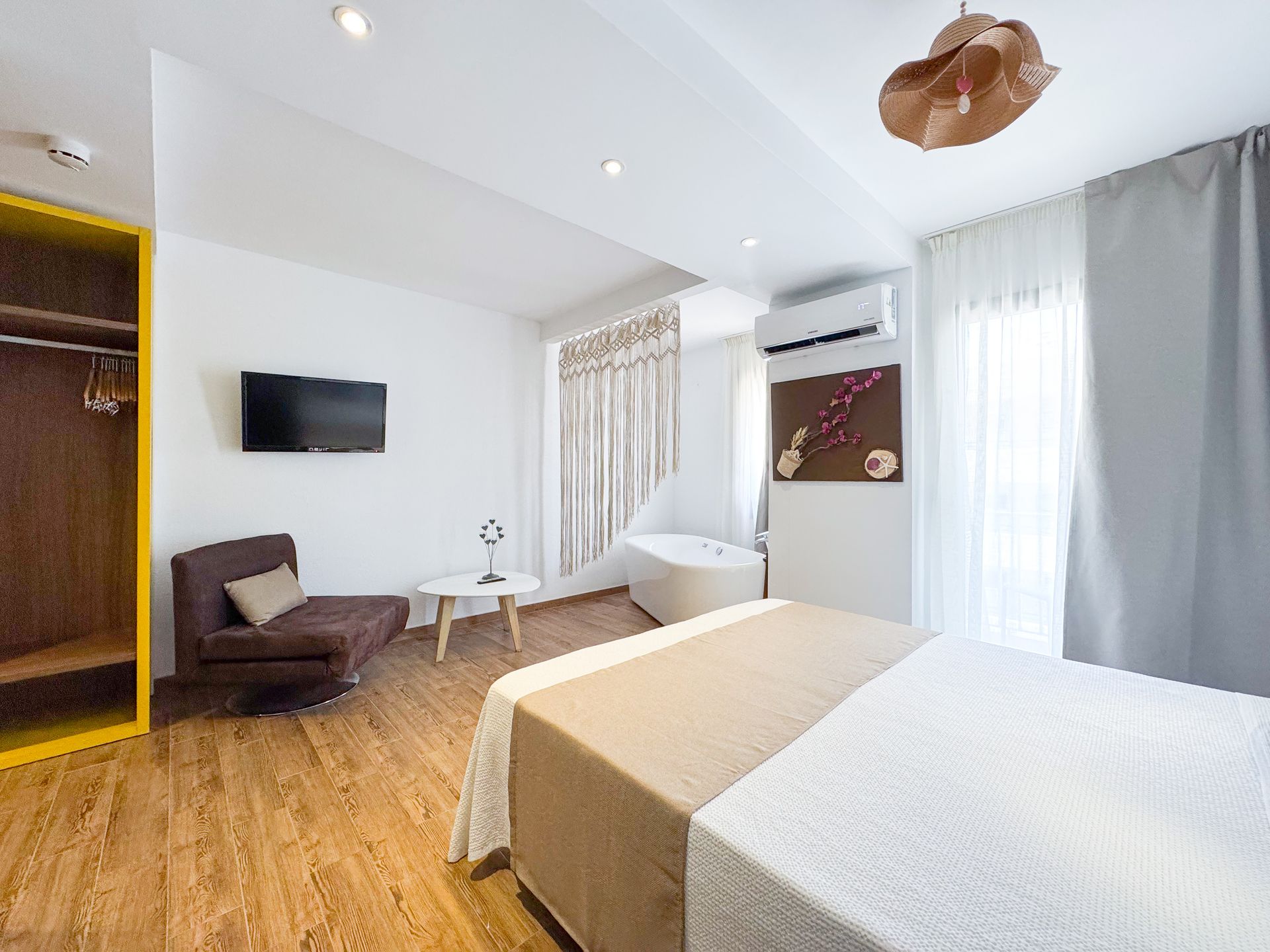 Una habitación de hotel con cama, silla, televisión y bañera.