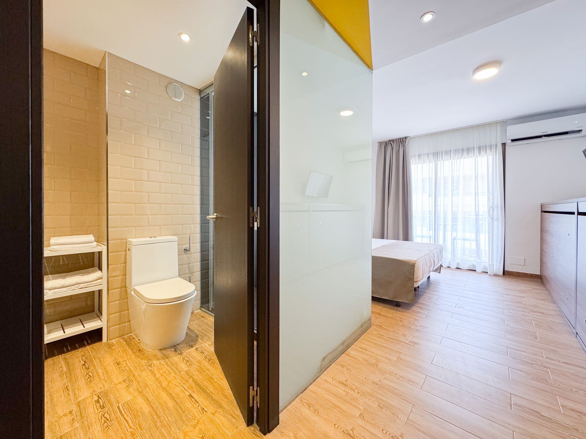 Una habitación de hotel con baño, ducha y cama.