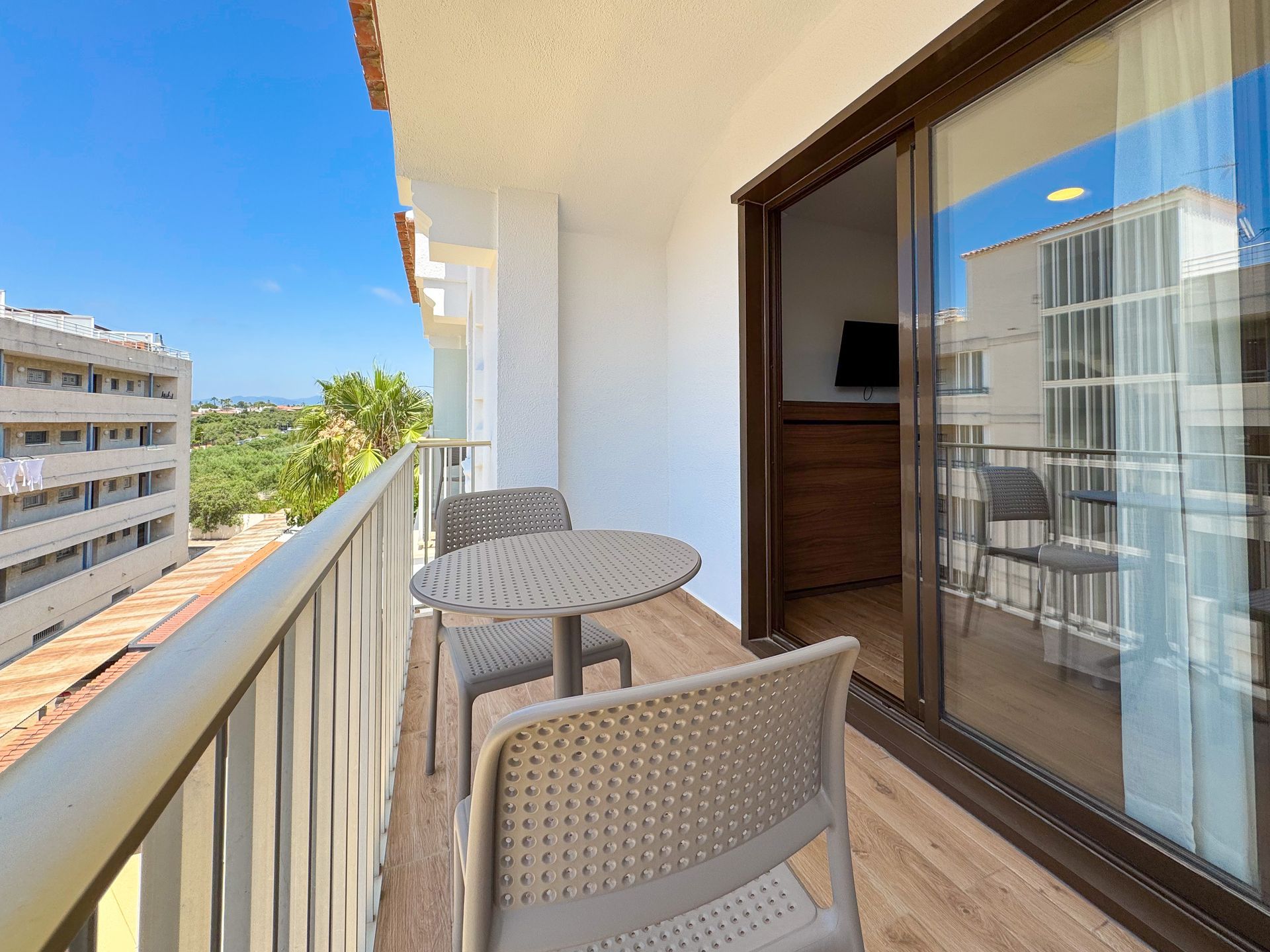 Hay un balcón con una mesa y sillas.