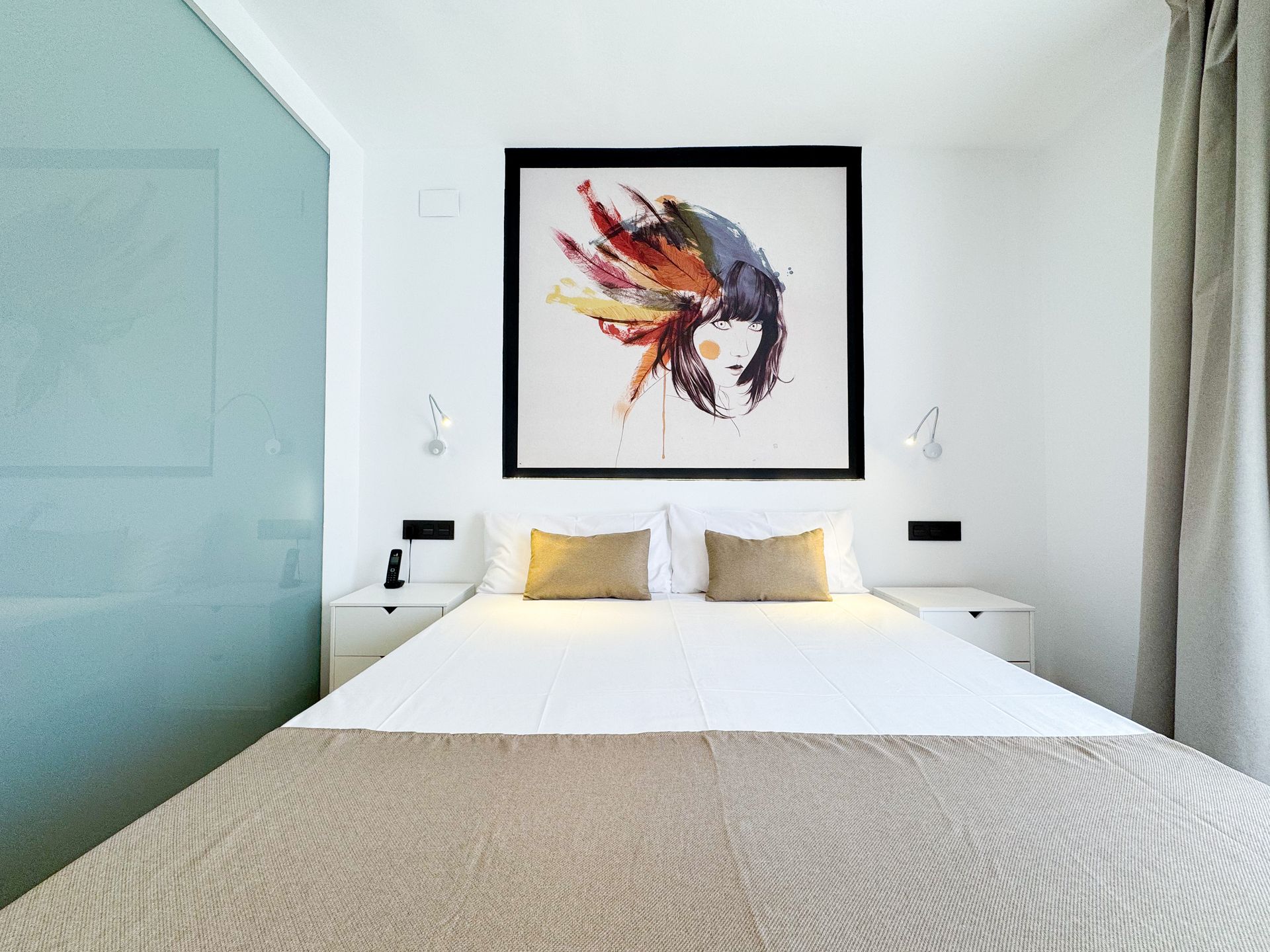 A hotel room with a painting of a woman on the wall