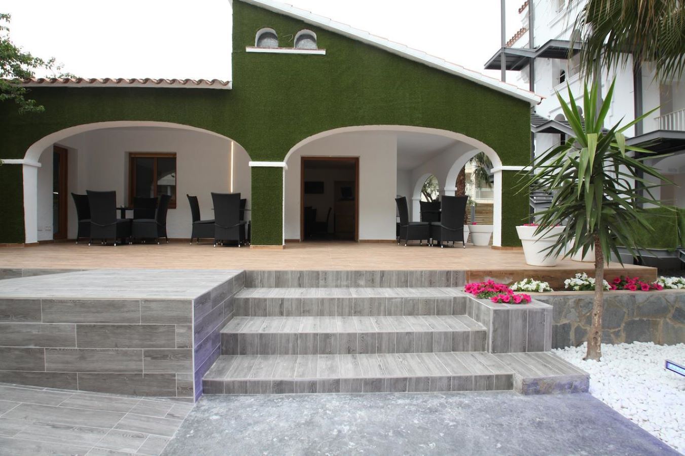A green and white house with stairs leading up to it
