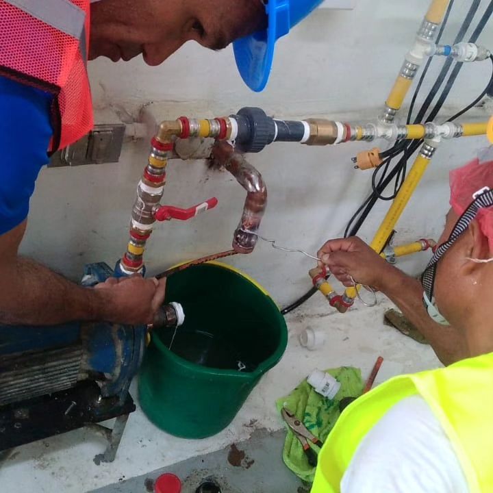 Un hombre que lleva un casco está trabajando en una tubería.