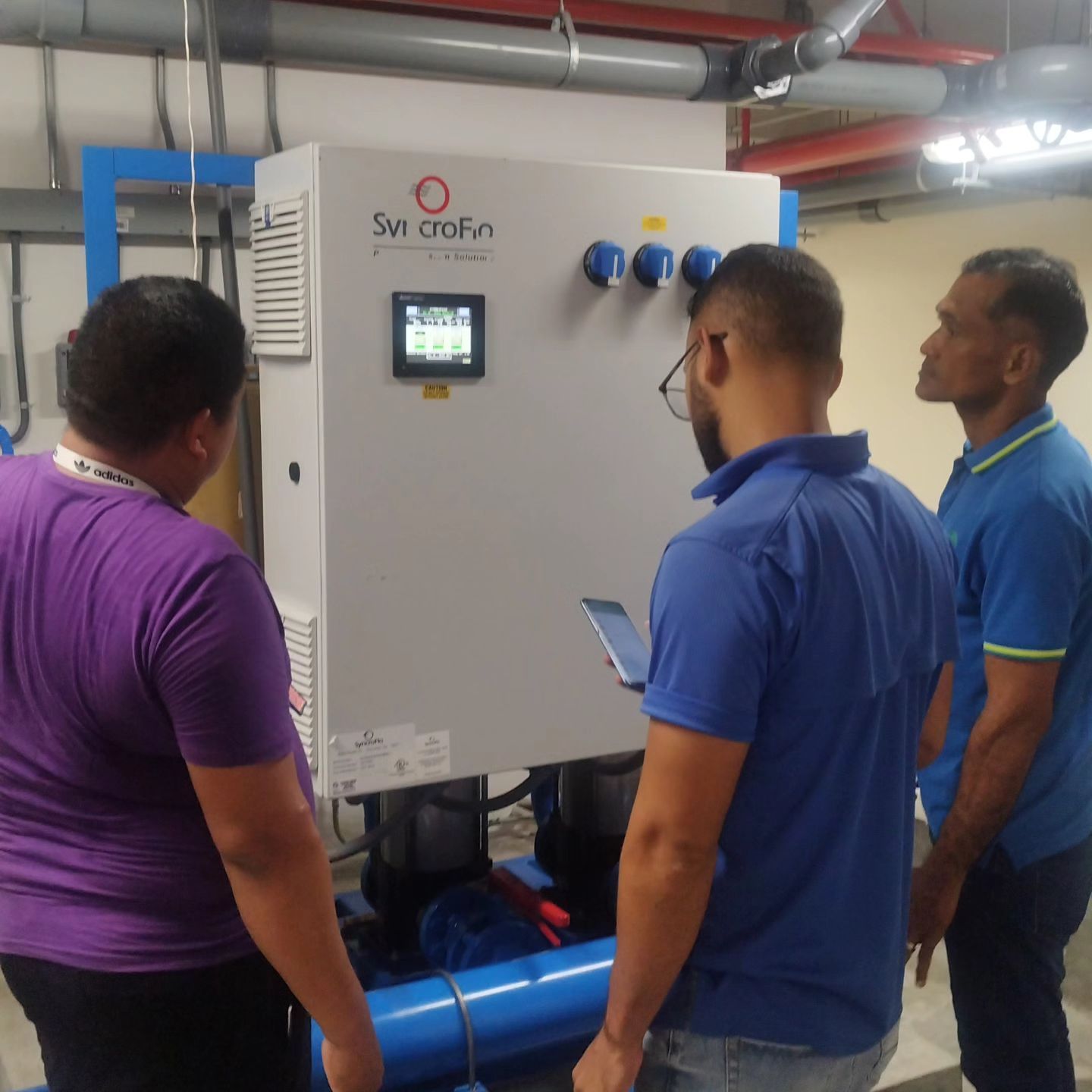 Un grupo de hombres se encuentra frente a un panel de control de SW Crofin.