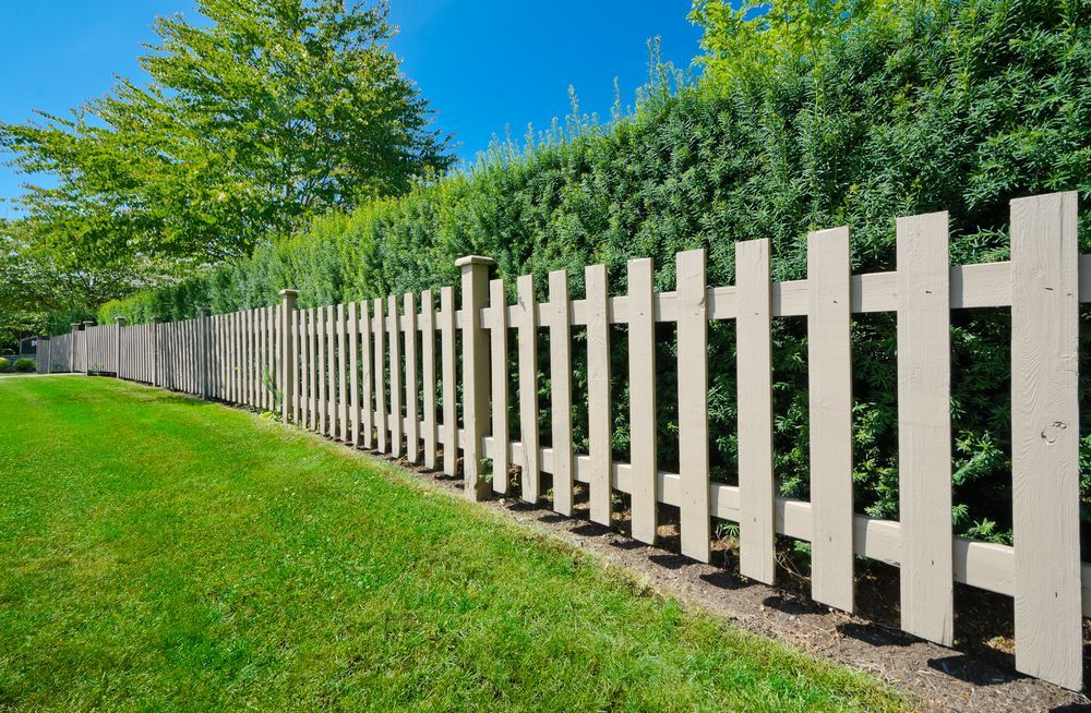 A Beige Picket Fence Borders — Smiddy's Services In Morisset, NSW